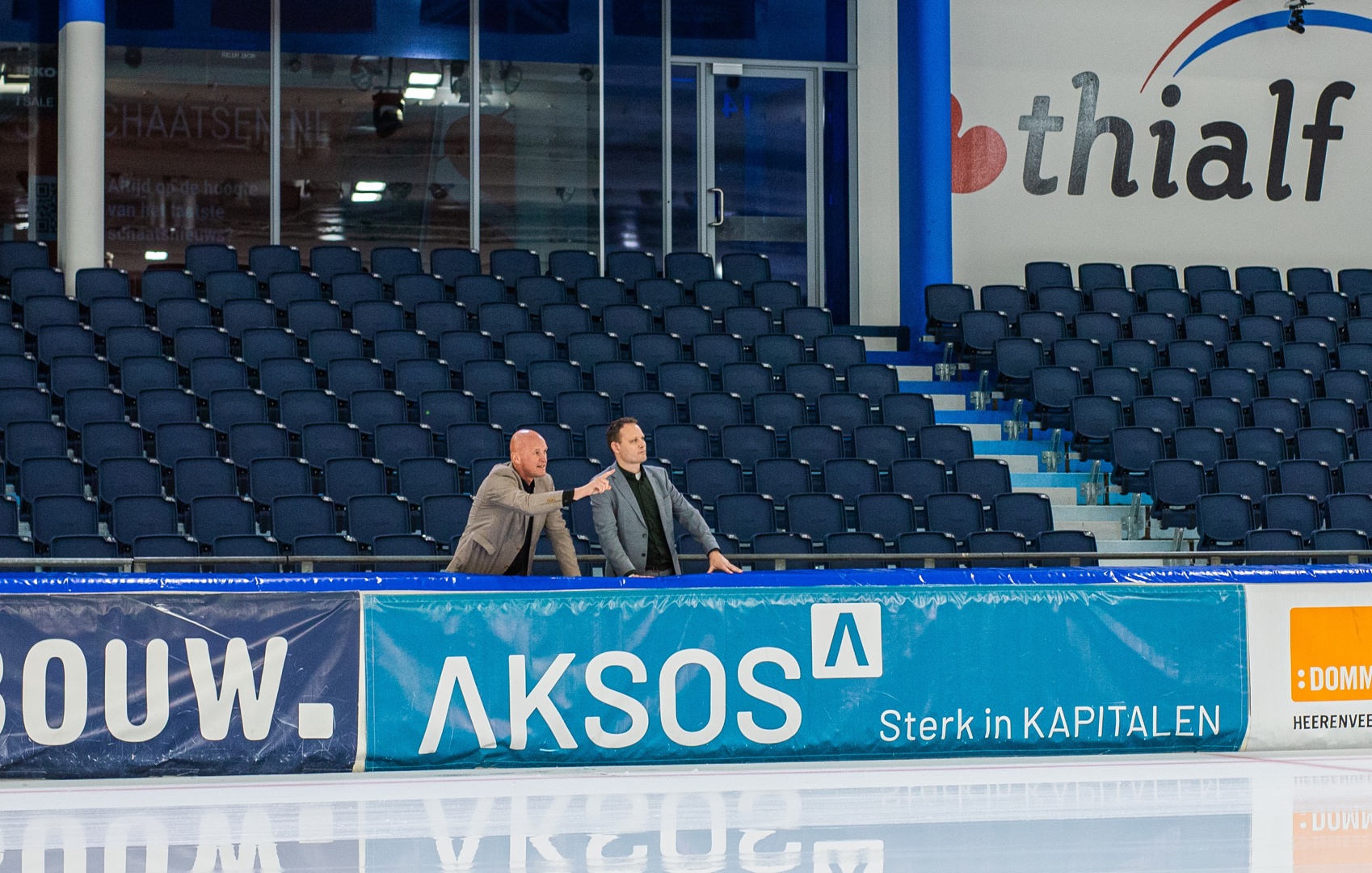 Minne Dolstra van Thialf wijst vanaf de Thialf tribune iets aan voor Cor Elsinga van AKSOS
